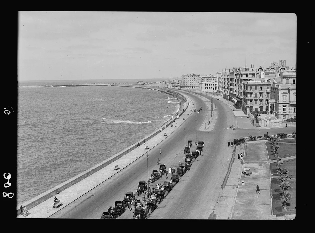 An old black-and-white photograph of the curved waterfront and harbor at Alexandria, Egypt