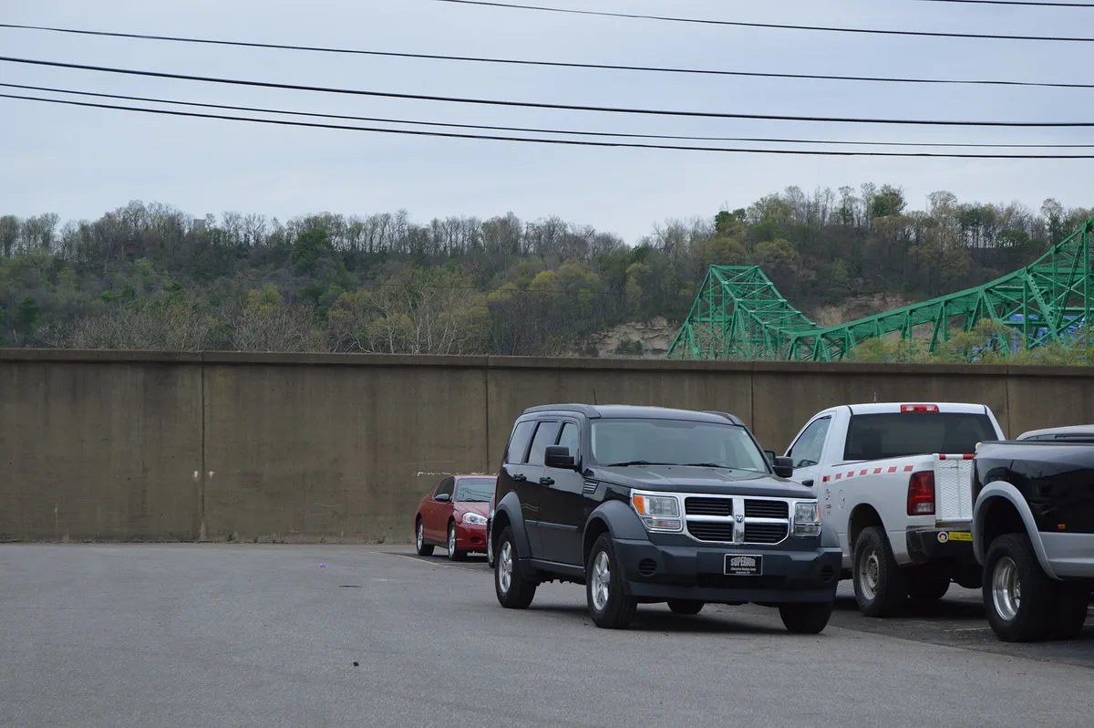 Two pickup trucks and an SUV parked in a row against a concrete wall