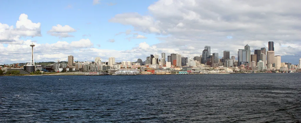 The downtown Seattle skyline seen across the water of Elliott Bay under clouds