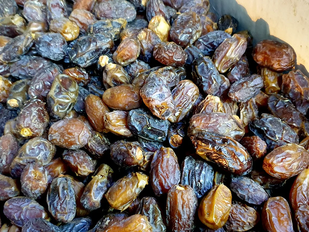 A heap of glossy brown dates seen up close