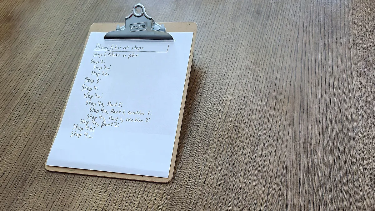 A clipboard holding a handwritten list of numbered steps on a wooden table
