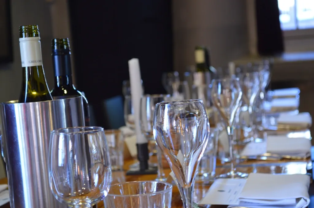 Wine glasses and bottles in an ice bucket on a set dining table