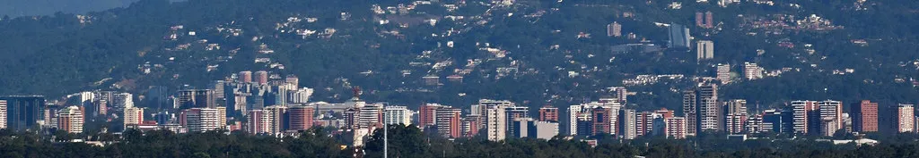 High-rise apartment towers of Guatemala City in front of green hills