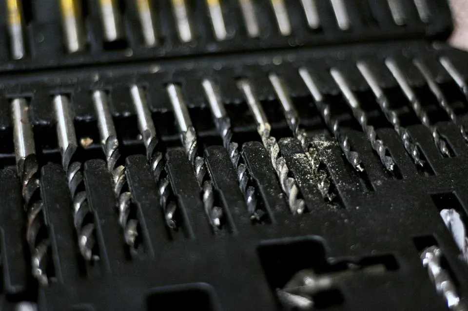 Close-up of a row of steel drill bits in a black plastic case